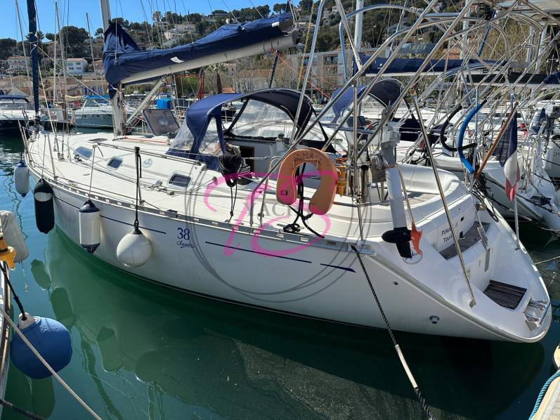 Voile colorée sur un voilier naviguant sur une mer calme.