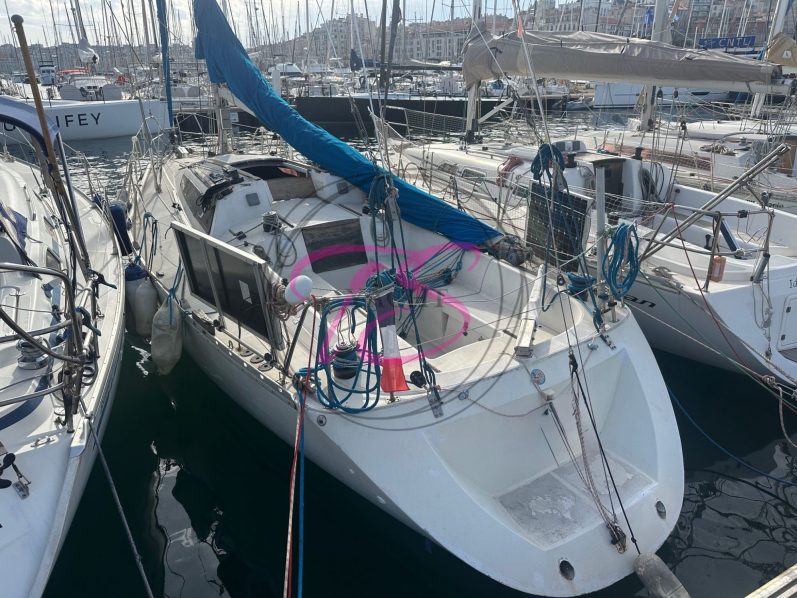 Voile colorée sur un voilier naviguant sur une mer calme.