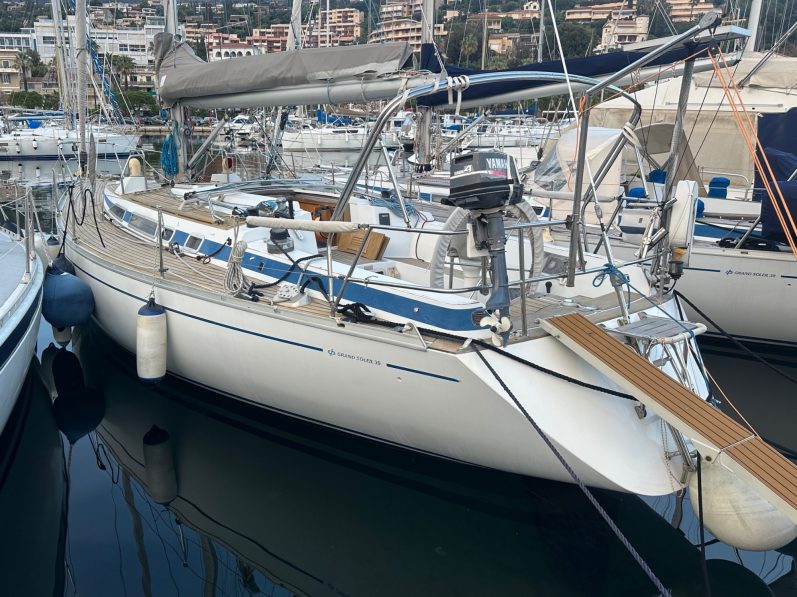 Voile colorée sur un voilier naviguant sur une mer calme.